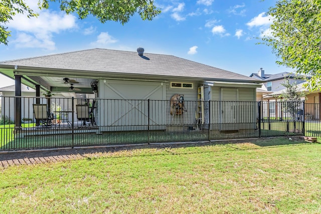 rear view of property with a yard and ceiling fan