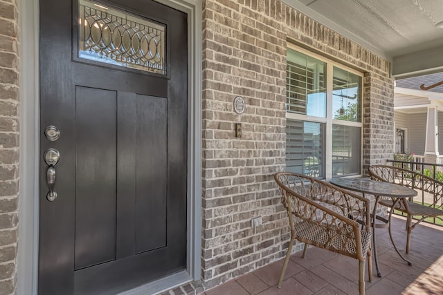 view of exterior entry featuring covered porch