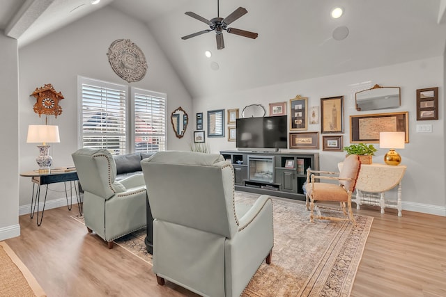 living room featuring ceiling fan, high vaulted ceiling, and light hardwood / wood-style flooring