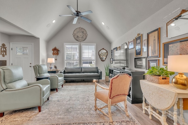 living room with light hardwood / wood-style floors, high vaulted ceiling, and ceiling fan