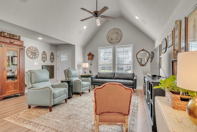 living room with high vaulted ceiling, light hardwood / wood-style floors, and ceiling fan