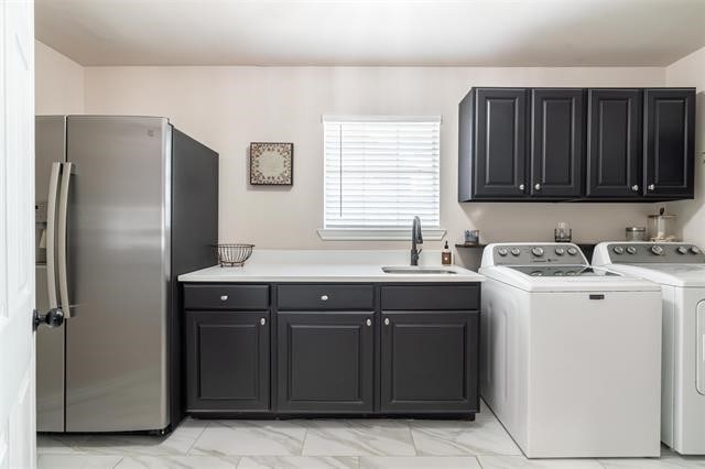 laundry area with sink, washer and dryer, and cabinets