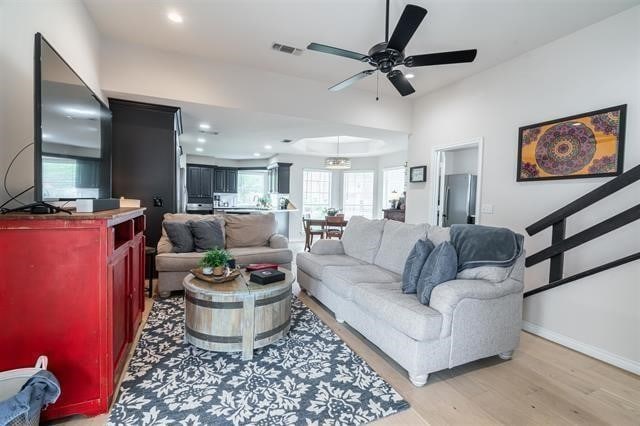 living room with light hardwood / wood-style flooring and ceiling fan