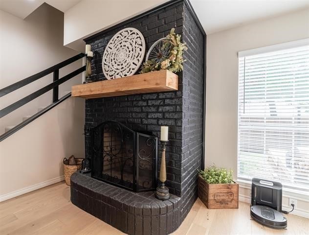 interior details featuring a brick fireplace and hardwood / wood-style floors