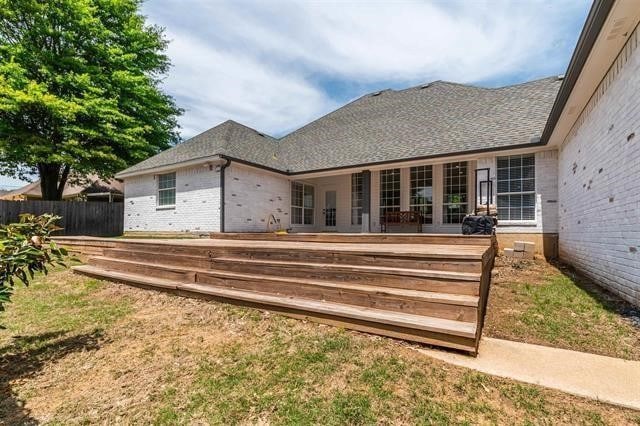 back of house featuring a lawn and a wooden deck