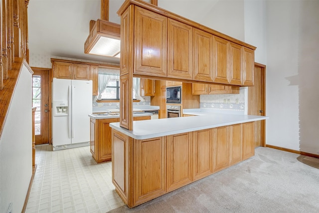 kitchen with light colored carpet, black microwave, decorative backsplash, white fridge with ice dispenser, and stainless steel oven