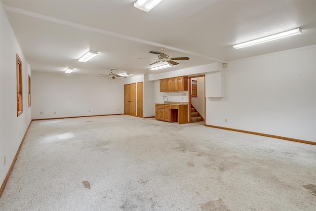 unfurnished living room with light colored carpet and ceiling fan