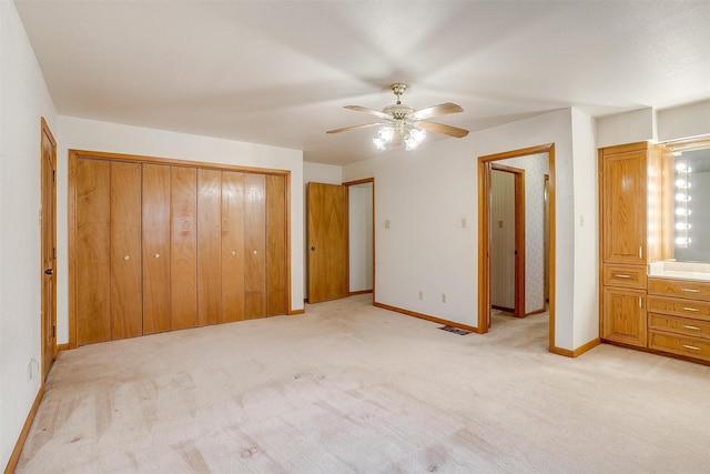 unfurnished bedroom with light colored carpet and ceiling fan