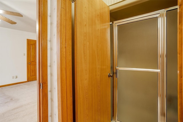 bathroom with an enclosed shower and ceiling fan