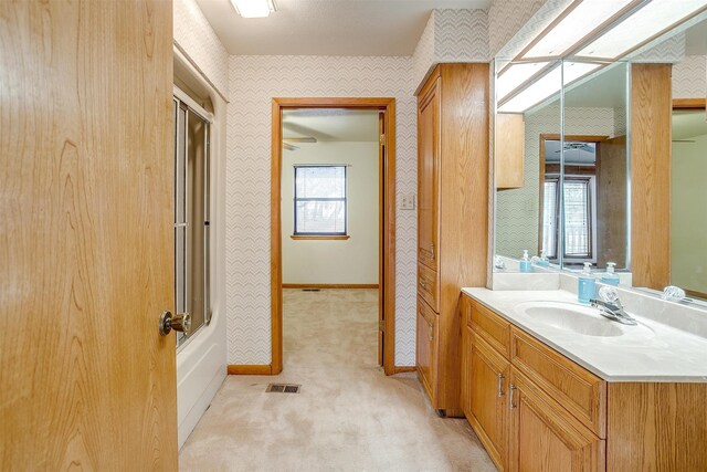 bathroom featuring shower / bath combination with glass door and vanity