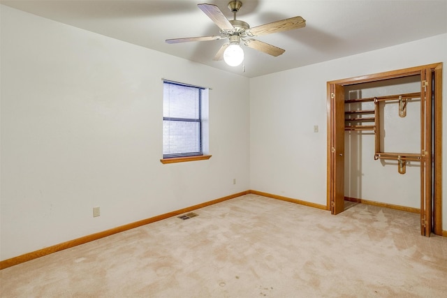 unfurnished bedroom with ceiling fan, light carpet, and a closet