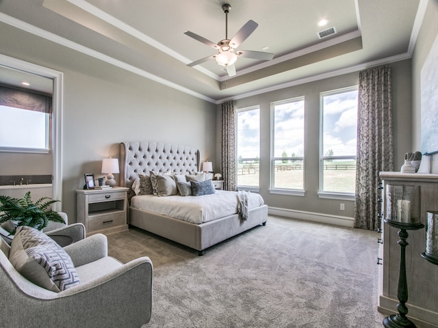 carpeted bedroom with ceiling fan, a raised ceiling, and ornamental molding