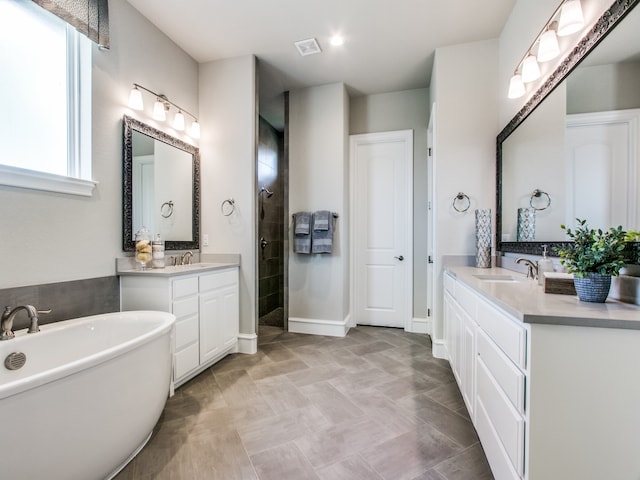 bathroom featuring a wealth of natural light, vanity, and plus walk in shower