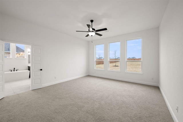 carpeted spare room featuring ceiling fan