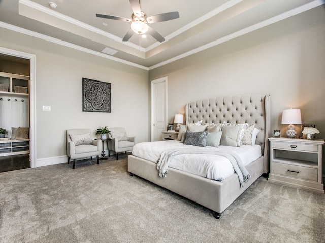 bedroom featuring light carpet, ceiling fan, and a raised ceiling