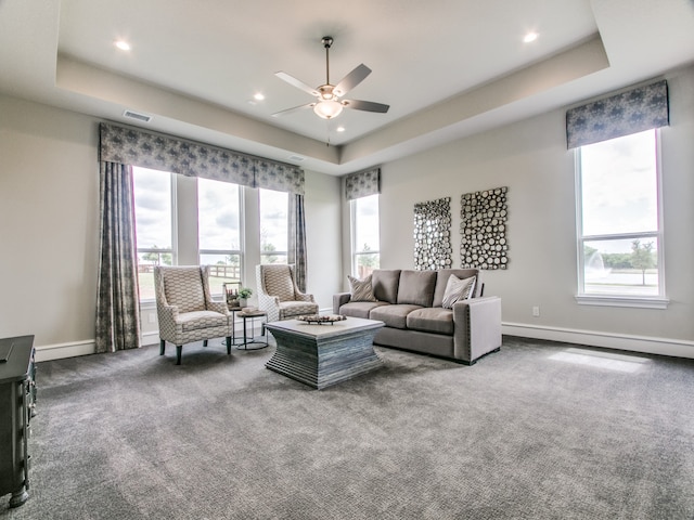 living room with a raised ceiling and a wealth of natural light