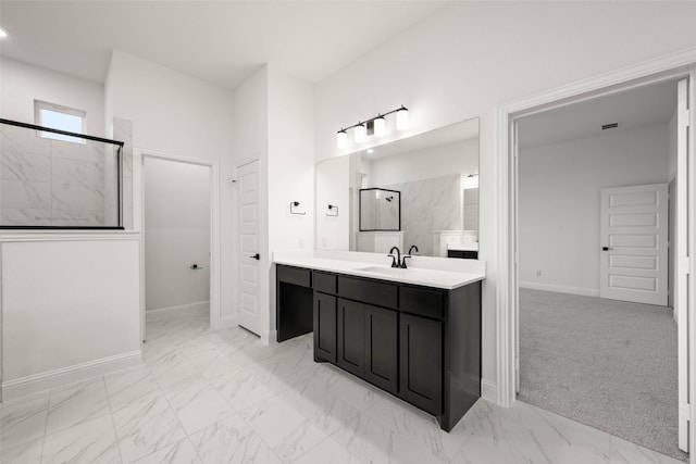 bathroom with a tile shower and vanity