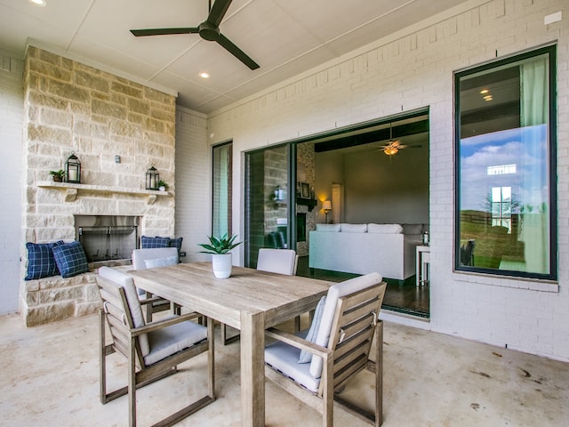 view of patio with an outdoor stone fireplace and ceiling fan