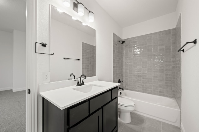 full bathroom with tile patterned flooring, vanity, tiled shower / bath, and toilet