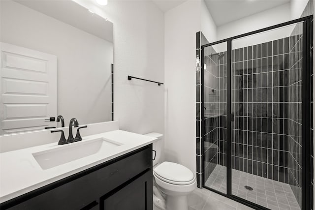 bathroom featuring tile patterned floors, toilet, vanity, and a shower with door