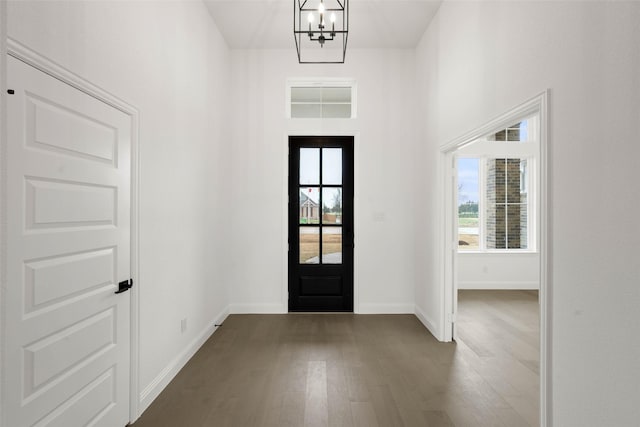 foyer featuring a notable chandelier, dark wood-type flooring, and a wealth of natural light