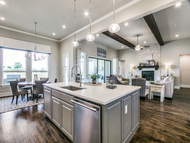 kitchen with sink, gray cabinetry, stainless steel dishwasher, a kitchen island with sink, and a fireplace