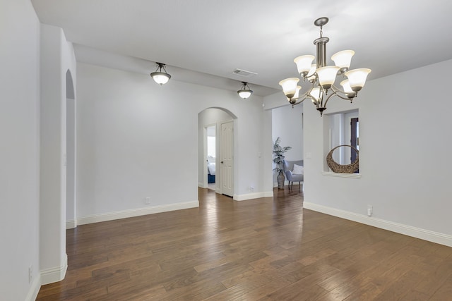 unfurnished room with dark hardwood / wood-style floors and a chandelier