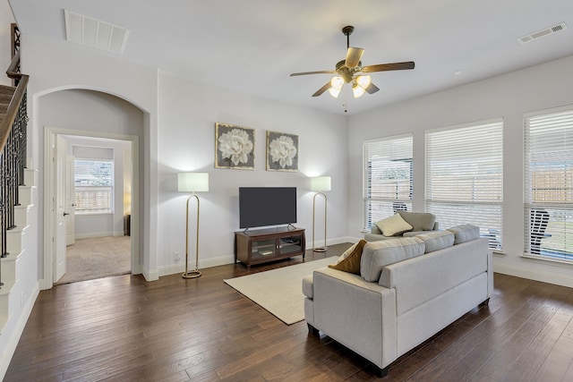 living room featuring ceiling fan and dark wood-type flooring