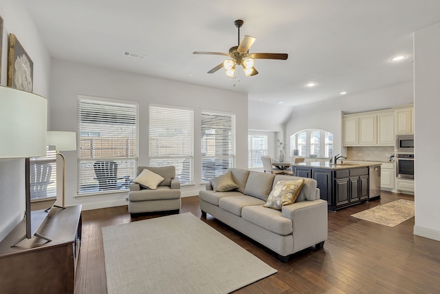 living room with dark hardwood / wood-style flooring, ceiling fan, and sink