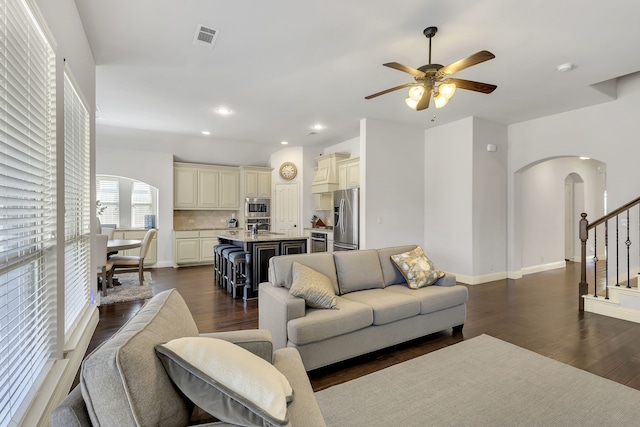 living room featuring ceiling fan, dark wood-type flooring, and sink