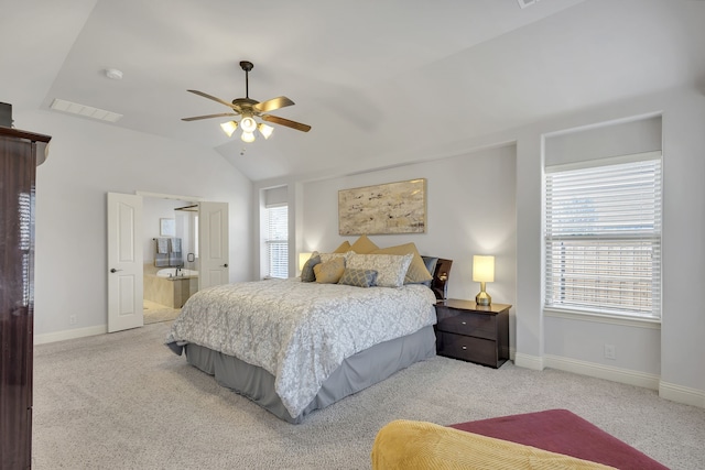 bedroom with ceiling fan, ensuite bath, vaulted ceiling, and multiple windows