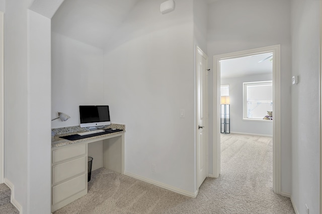 home office featuring built in desk and light colored carpet