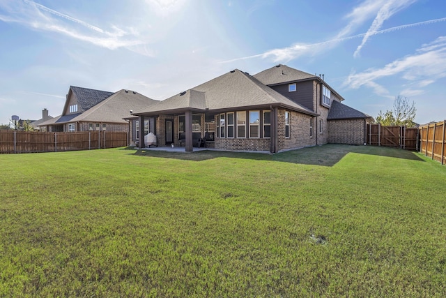 back of house featuring a lawn and a patio