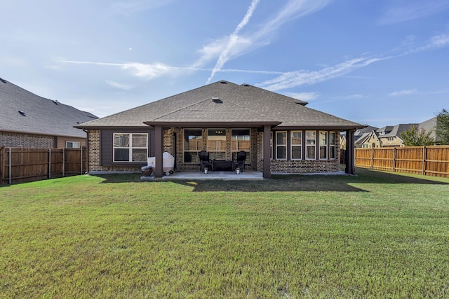 back of house with a lawn and a patio