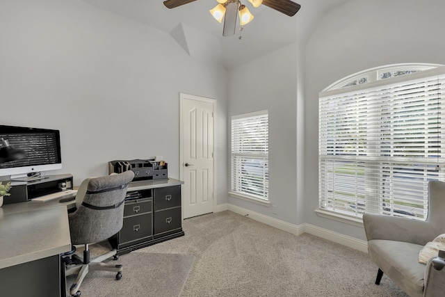 office area with vaulted ceiling, ceiling fan, and light colored carpet