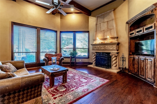 living room with crown molding, ceiling fan, dark hardwood / wood-style flooring, beam ceiling, and a fireplace