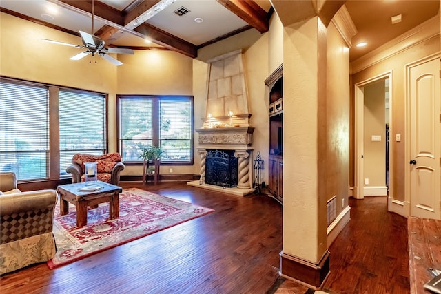 living room featuring crown molding, dark hardwood / wood-style flooring, a fireplace, coffered ceiling, and beamed ceiling