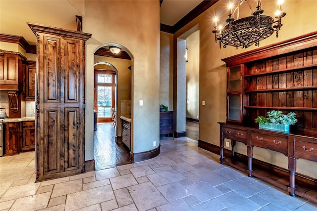 kitchen with a chandelier, crown molding, and stainless steel electric range