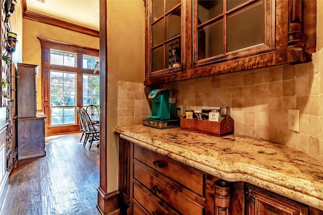 kitchen with light stone counters, hardwood / wood-style floors, and crown molding