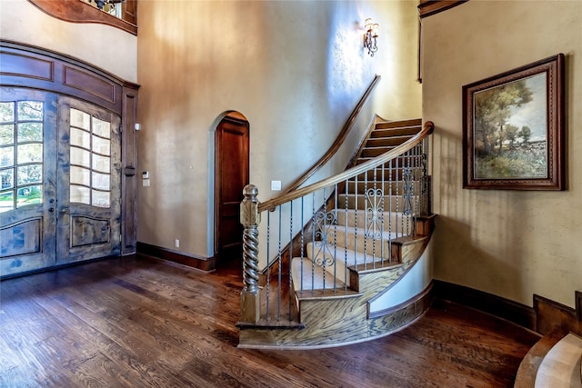 foyer entrance with french doors, a high ceiling, and dark hardwood / wood-style flooring