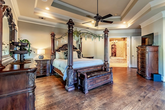 bedroom featuring ceiling fan, a raised ceiling, dark hardwood / wood-style floors, ensuite bath, and ornamental molding