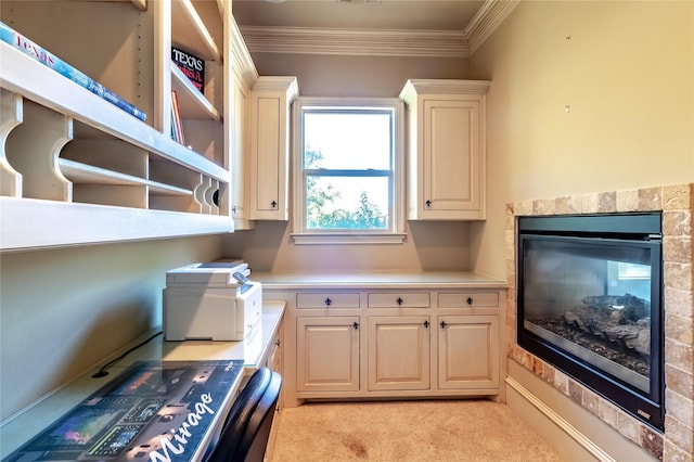 laundry area featuring ornamental molding, light colored carpet, a fireplace, and cabinets