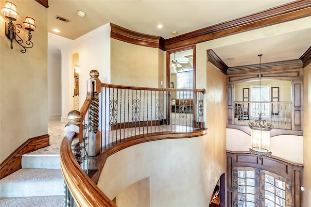 stairs with ceiling fan and ornamental molding