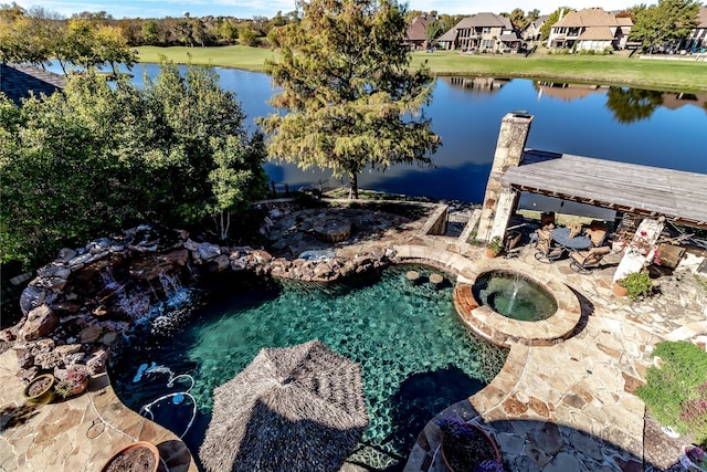 view of pool with an in ground hot tub and a water view