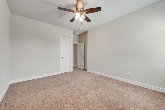 spare room with ceiling fan and light colored carpet