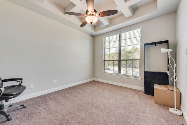 carpeted office with a tray ceiling, coffered ceiling, and ceiling fan