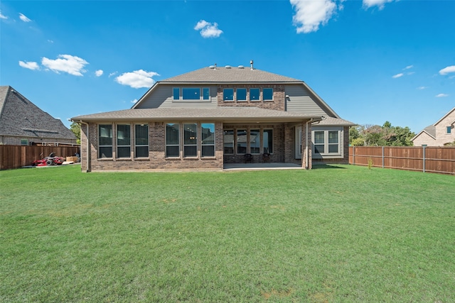 back of property with a lawn and a patio area