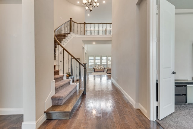 entryway with an inviting chandelier, a high ceiling, and hardwood / wood-style floors