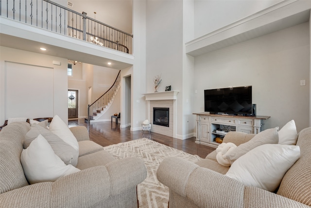 living room with a high ceiling and dark wood-type flooring