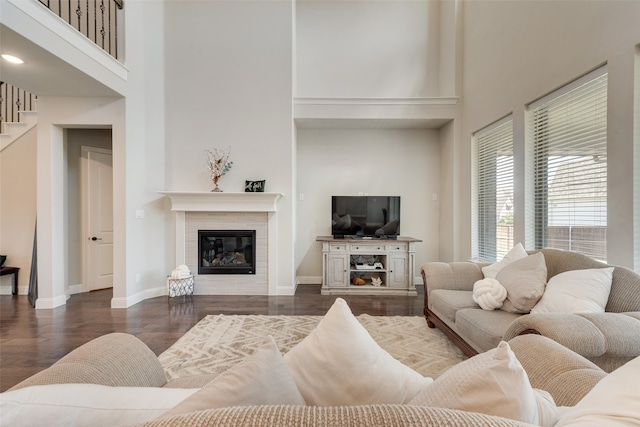 living room with dark hardwood / wood-style floors and a towering ceiling